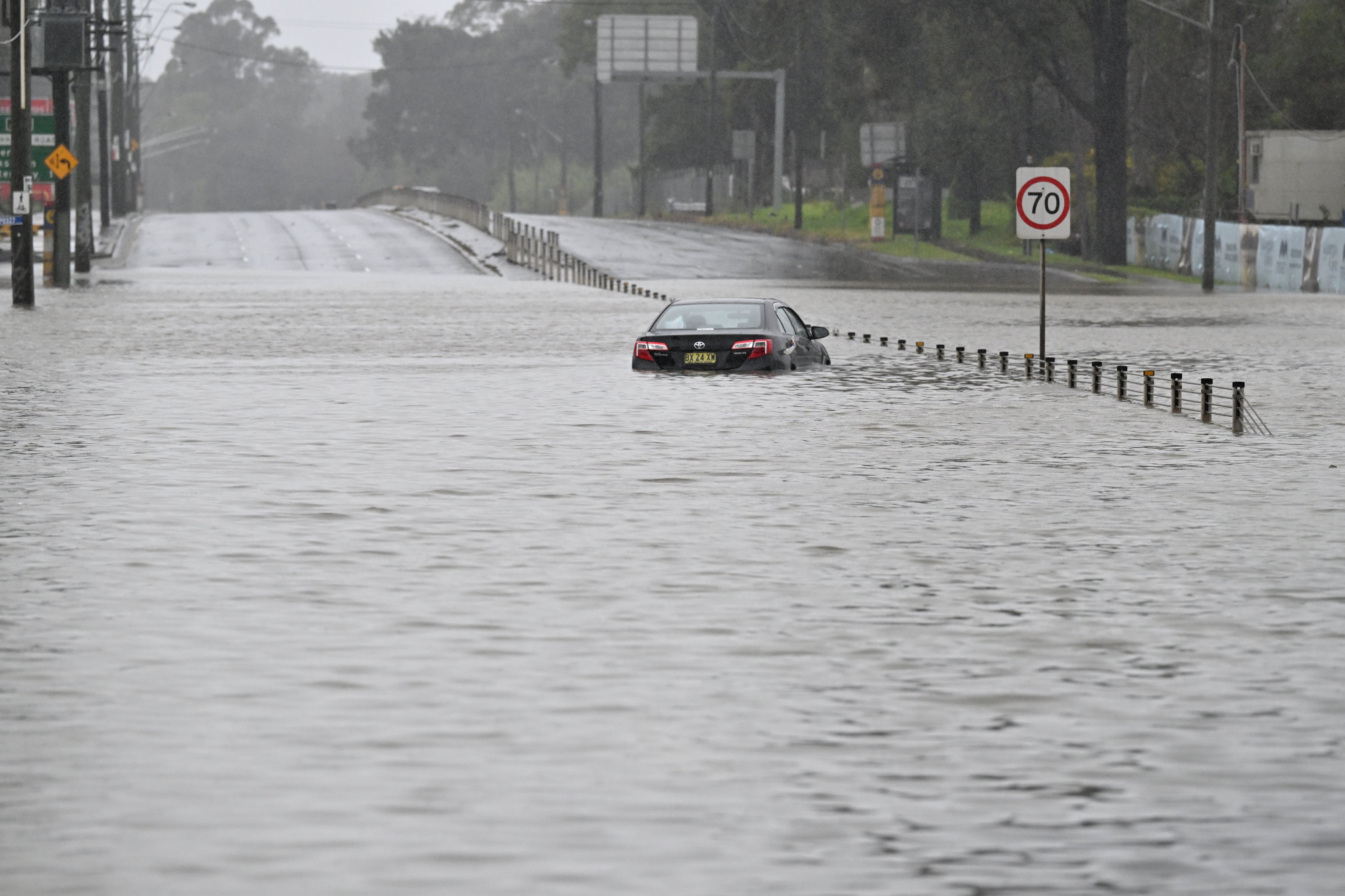An abandoned car is seen in floodwaters on Newbridge Road in Chipping Norton in western Sydney, Australia.