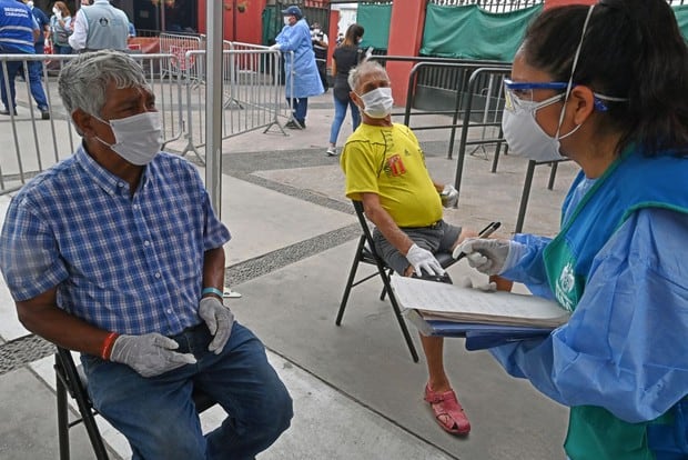 Personas sin hogar son entrevistadas por el personal de salud a su llegada a un refugio establecido en la plaza de toros de Acho, en Lima, durante la cuarentena a causa del nuevo coronavirus, COVID-19 (Foto: Cris Bouroncle / AFP)