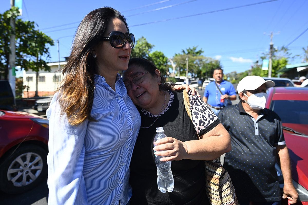 Housing Minister Michelle Sol (L) with Ana Vilma Cuéllar, a woman who bought a house 20 years ago but never lived there for fear of gangs in La Campanera, municipality of Soyapango, El Salvador, on January 13, 2023. (Photo by Marvin RECINOS / AFP)