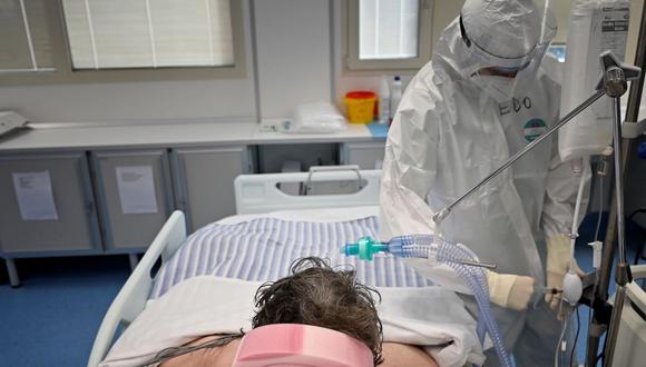 Un trabajador médico atiende a paciente de coronavirus en la unidad de cuidados intensivos del Instituto de Cardiología Clínica (ICC) de Roma, Italia, el 30 de diciembre de 2021. (Alberto PIZZOLI / AFP).