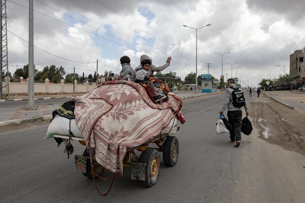 Los palestinos desplazados internos, incluidos niños, cargan sus pertenencias en un carro tirado por burros después de una orden de evacuación emitida por el ejército israelí en Rafah. (EFE/EPA/HAITHAM IMAD).