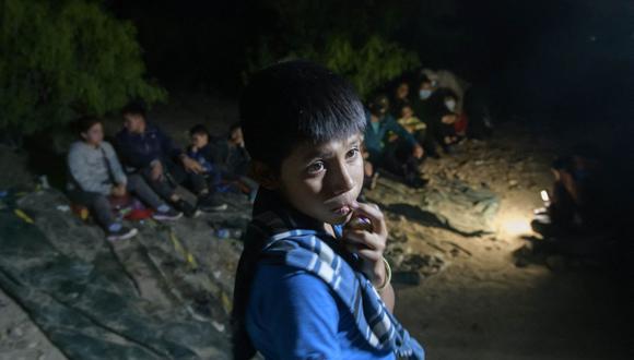 En una foto tomada el 27 de marzo de 2021, el niño inmigrante guatemalteco no acompañado Oscar (12), quien llegó ilegalmente al otro lado del río Grande desde México, está parado después de desembarcar de un bote cerca de la ciudad fronteriza de Roma, en Estados Unidos. (Foto de Ed JONES / AFP).