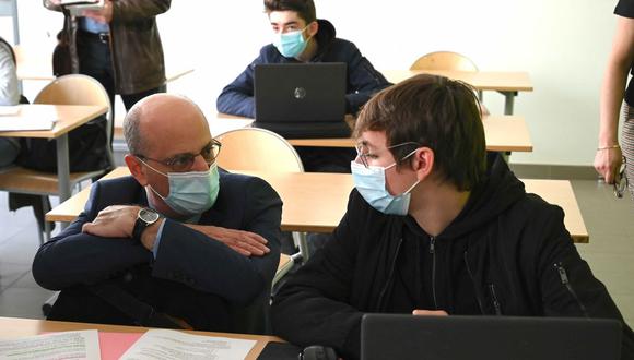 El ministro de Educación de Francia, Jean-Michel Blanquer, conversa con un estudiante durante una visita a una escuela secundaria, en Laxou, tras el inicio del desconfinamiento por coronavirus. (Foto de PATRICK HERTZOG / AFP).