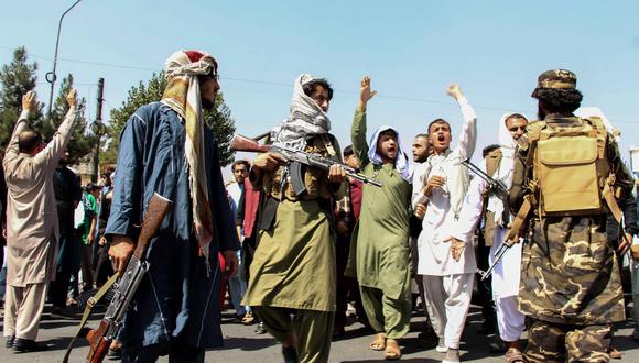Las fuerzas del Talibán montan guardia mientras los afganos sostienen pancartas gritando consignas contra Pakistán durante una protesta en Kabul, Afganistán, el 7 de septiembre de 2021. (EFE / EPA / STRINGER).