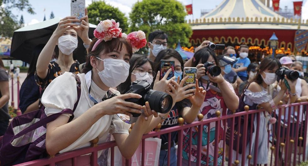 Las visitantes toman fotos al icónico personaje de dibujos animados Minnie Mouse en el parque de Disney en Hong Kong. (AP/Kin Cheung).