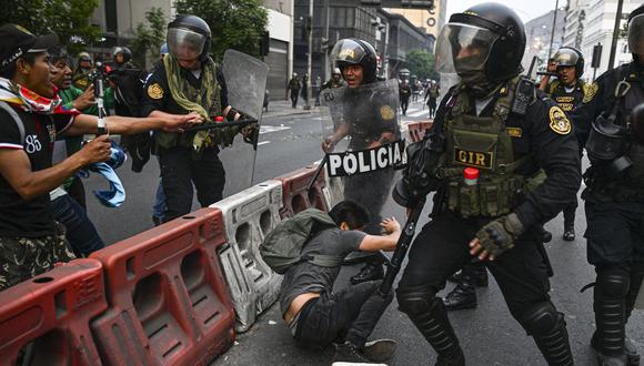 La gente se enfrenta a la policía antidisturbios durante una manifestación que exige la liberación del expresidente Pedro Castillo y el cierre del Congreso peruano, en Lima, un día después de la destitución de Castillo.