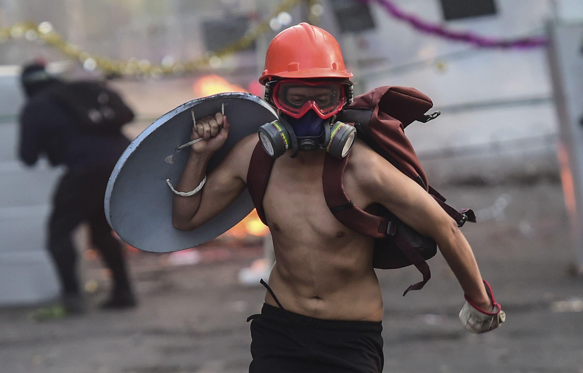 Un manifestante carga un escudo improvisado durante una protesta en Santiago de Chile. (Photo by Martin BERNETTI / AFP).