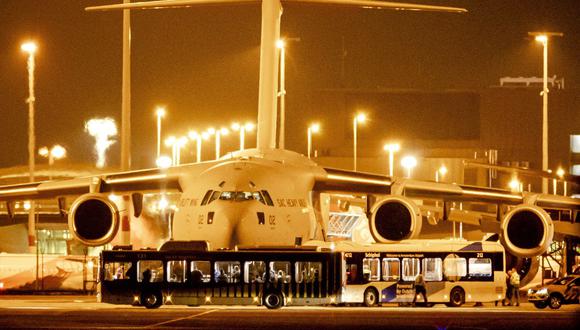 Pasajeros de Afganistán desembarcan de un avión C-17 utilizado por varios países de la OTAN en una plataforma del aeropuerto de Schiphol, cerca de Ámsterdam, el 18 de agosto de 2021. (ROBIN VAN LONKHUIJSEN / ANP / AFP).