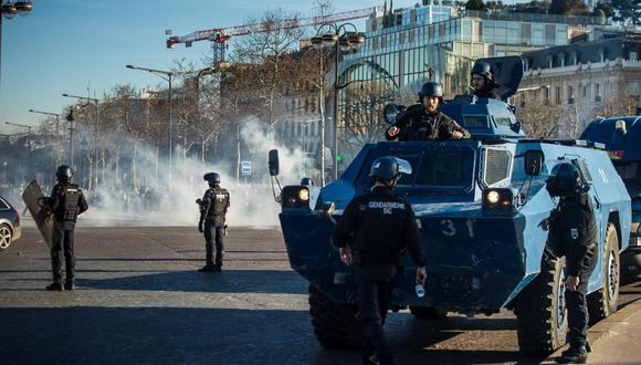 La policía de Francia lanza gases lacrimógenos en los Campos Elíseos mientras los participantes del llamado "Convoy de la Libertad" intentan bloquear el tráfico en París, el 12 de febrero de 2022. (EFE/EPA/CHRISTOPHE PETIT TESSON).