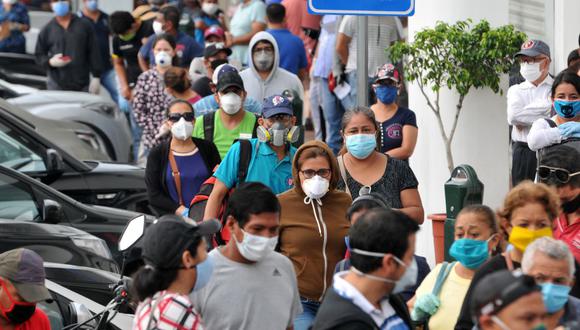 Las personas usan máscaras faciales mientras esperan en la fila frente a un banco en Guayaquil el 28 de abril de 2020, en medio de la nueva pandemia de coronavirus. (JOSE SANCHEZ LINDAO / AFP).