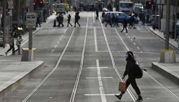 Una persona cruza la calle en el distrito central de negocios de Melbourne el 7 de julio de 2021, en medio de la pandemia de coronavirus. (Foto de William WEST / AFP).