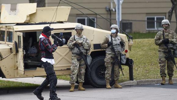 Un manifestante camina a lo largo de una línea formada por la policía y la Guardia Nacional frente al Departamento de Policía del Brooklyn Center mientras un pequeño grupo de manifestantes se reúne en Brooklyn Center, Minnesota, EE. UU. (Foto: EFE / EPA / CRAIG LASSIG).