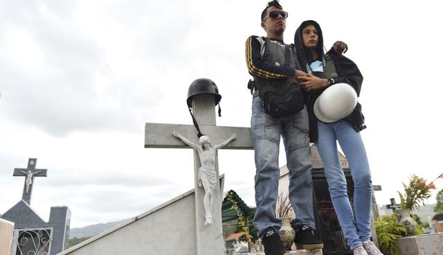 Friends of 15-year-old Jose Francisco Guerrero, who was shot when he went to buy some food and was found trapped in a confrontation between looters and the National Guard in the framework of protests against the government of President Nicolas Maduro, attend his funeral in San Cristobal, Tachira State, Venezuela, on May 19, 2017. Despite its vast oil reserves, Venezuela is suffering chronic shortages of food, medicine and other basic supplies. The center-right opposition blames it all on mismanagement and corruption in the Socialist government.  / AFP / LUIS ROBAYO