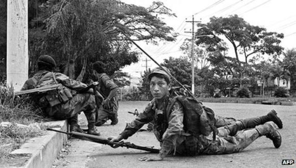 Esta fotografía captada en noviembre de 1989, muestra a tropas del ejército salvadoreño apostadas frente al campus 12 de la Universidad Nacional, controlada por los rebeldes del Frente Farabundo Martí para la Liberación Nacional (FMLN). (Archivo AFP)