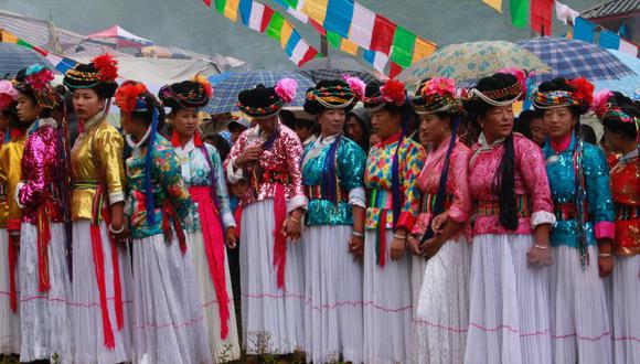 Mujeres de Mosuo son fotografiadas con trajes típicos, listas para bailar durante una fiesta de la comunidad. (Choo Waihong / Ediciones Península / Efeminista / EFE).