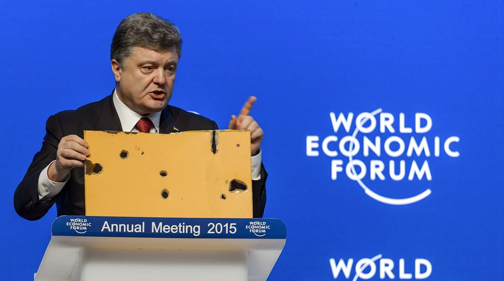 El presidente ucraniano Petro Poroshenko sostiene un pedazo de un bus que fue impactado por un cohete cerca de Volnovakha, evento en el cual murieron 13 personas, durante su presentaci&oacute;n en el Foro Econ&oacute;mico de Davos, que se inici&oacute; h