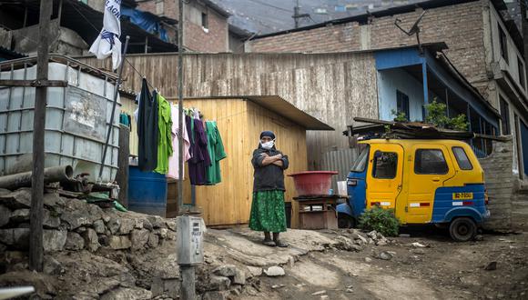 Una mujer se encuentra fuera de su casa en Pamplona Alta, que sufre escasez de agua, en las afueras del sur de Lima el 28 de mayo de 2020, durante la nueva pandemia de coronavirus. (Foto por ERNESTO BENAVIDES / AFP).