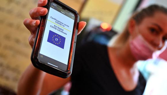 Una cliente muestra su Green Pass en un teléfono móvil en un bar del centro de Roma, Italia, el 6 de agosto de 2021, en medio de la pandemia de coronavirus. (Andreas SOLARO / AFP).