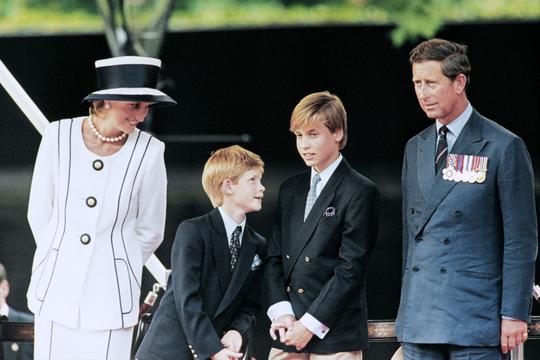 (FILES) In this file photo taken on August 19, 1995 Prince Charles (L), Princess Diana (R) and their children William (2nd L) and Harry watch the march past on a dais on the mall as part of the commemorations of VJ Day on August 19, 1995. Scarred by the death of his mother, Prince Harry has struggled in the royal limelight for much of his life, and his fears for wife Meghan have now put him at loggerheads with his family. / AFP / Johnny EGGITT
