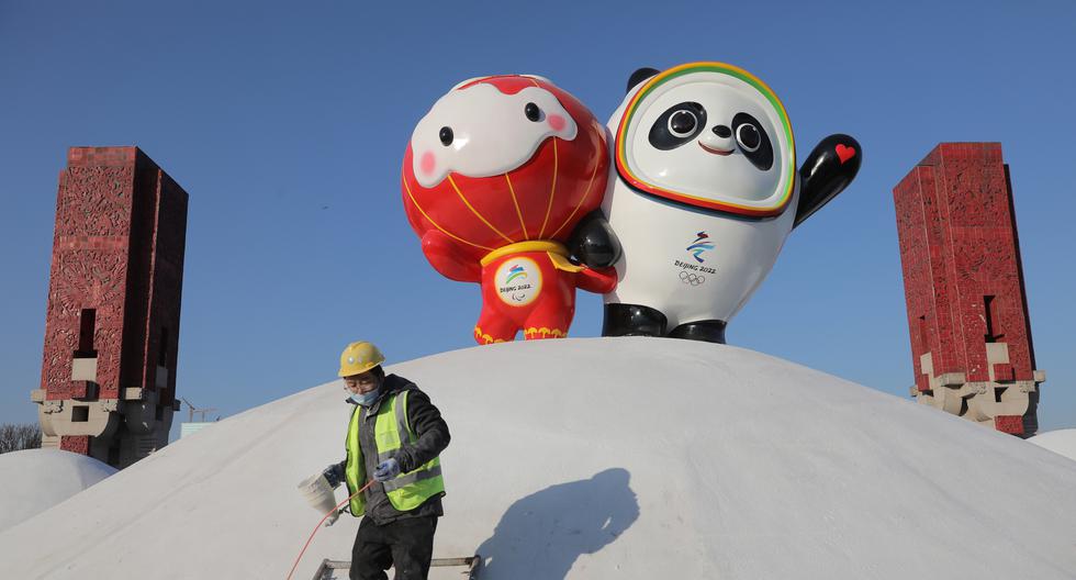 Un operario pinta junto a las mascotas de los Juegos Olímpicos de Invierno Pekín 2022, Bing Dwen Dwen, y la de los Paralímpicos 2022, Shuey Rhon Rhon, en Pekín, siendo la primera capital en albergar ambos Juegos de Verano (2008) y de Invierno (2022). EFE/WU HONG