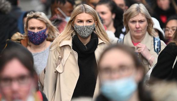 Las compradoras, algunas con mascarillas, caminan por Oxford Street, en el centro de Londres, el 4 de diciembre de 2021, en pleno rebrote del coronavirus en el Reino Unido. (Daniel LEAL / AFP).