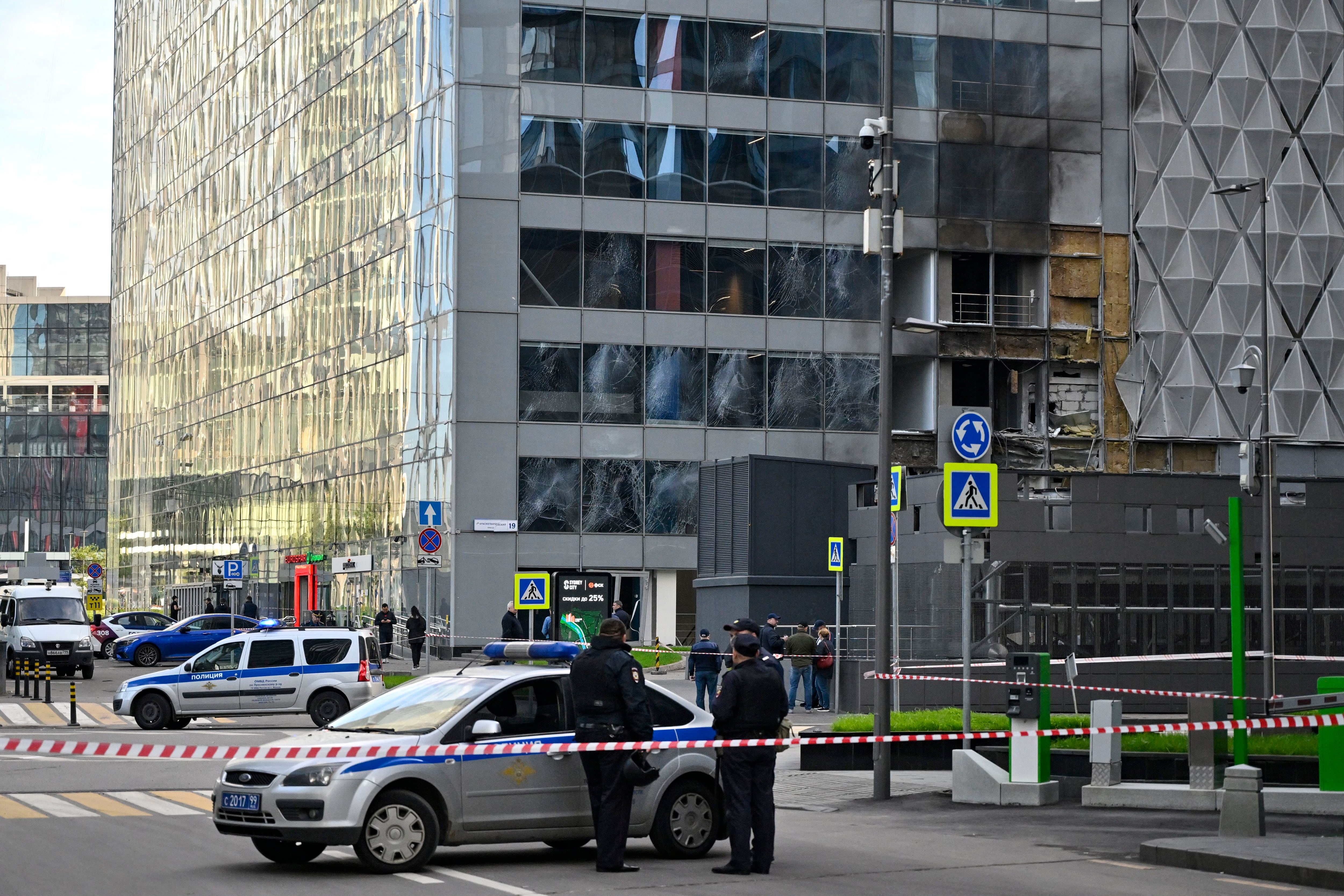 Police officers block off an area around a damaged Moscow International Business Center (Moskva City) office block following a drone strike in Moscow on July 30, 2023. (Photo by Alexander NEMENOV/AFP)