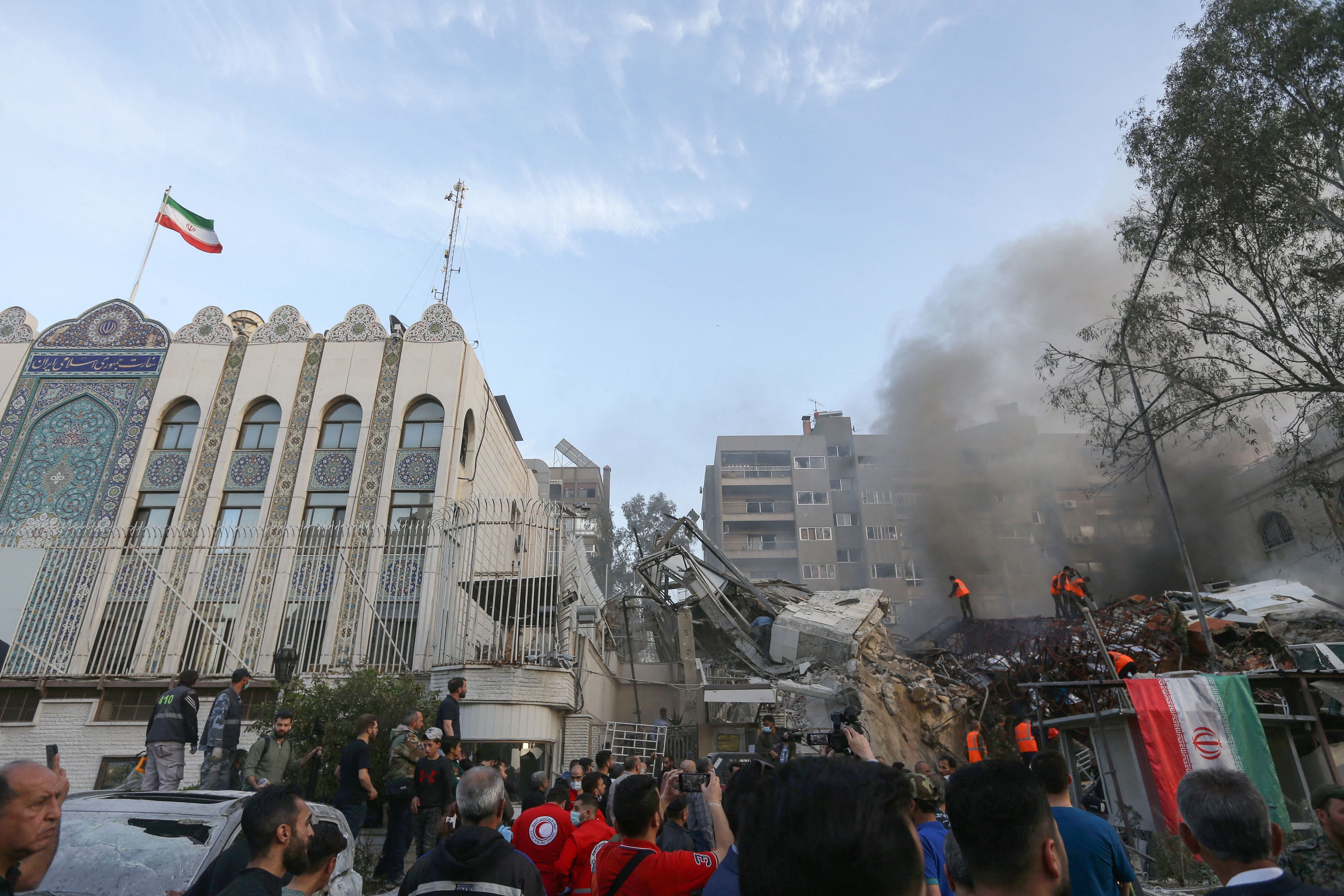 Emergency and security teams search the rubble at the site of the attacks that hit the Iranian consulate in the Syrian capital, Damascus.  (Photo by LOUAI BESHARA/AFP).