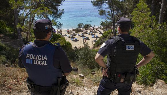 Imagen referencial. La policía local observa a la gente en la isla de Mallorca, el 30 de mayo de 2020. (JAIME REINA / AFP).