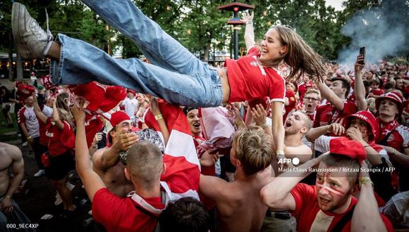 Los fanáticos del fútbol danés reaccionan al primer gol de su equipo mientras ven el partido de la semifinal de la UEFA EURO 2020 entre Inglaterra y Dinamarca en Copenhague, el 7 de julio de 2021 (Foto de Mads Claus Rasmussen / Ritzau Scanpix / AFP).