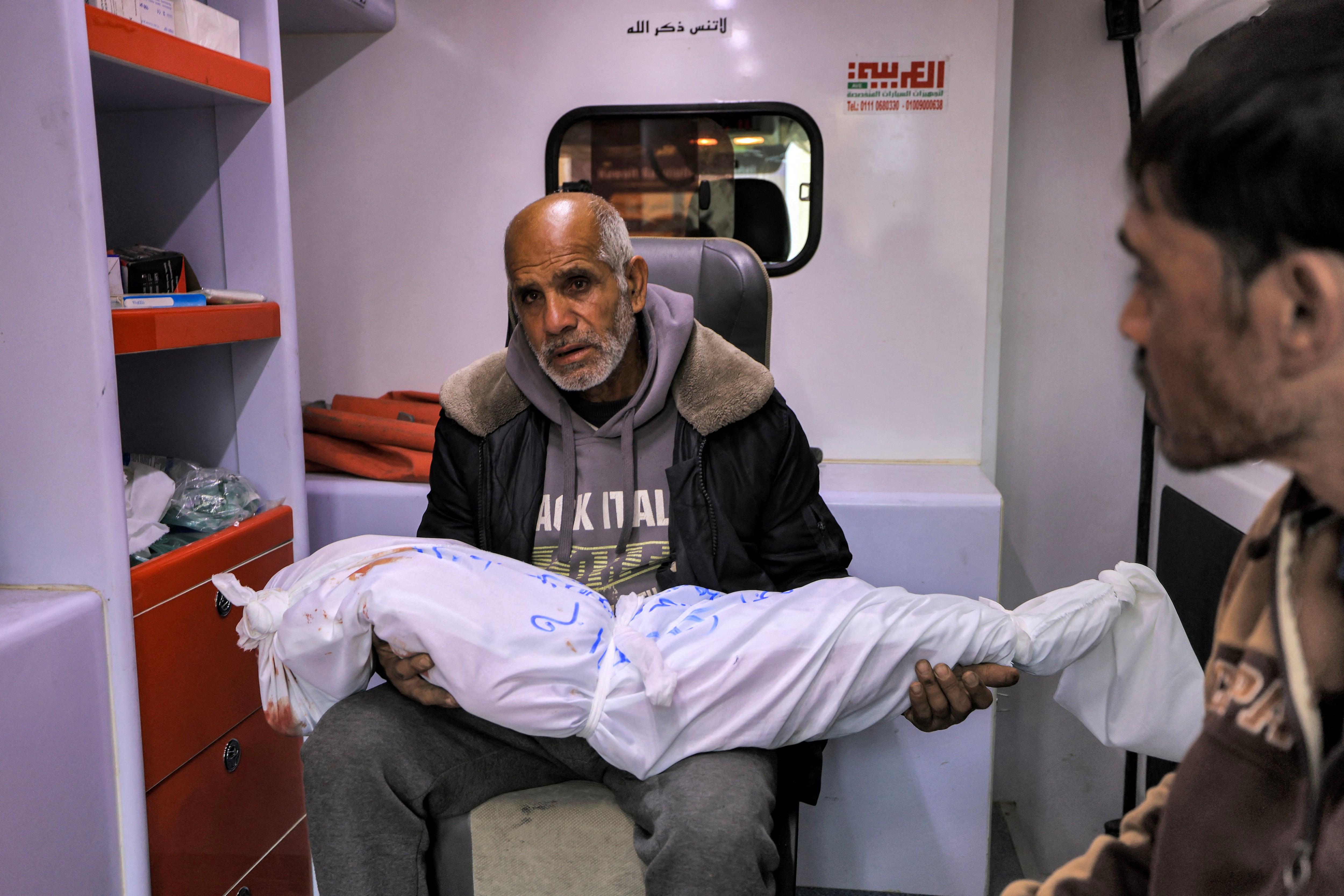 The grandfather of Sidal Abu Jamea, a Palestinian girl from Khan Yunis, carries her wrapped body after she was killed during an Israeli bombing raid.  (Photo by Mahmud HAMS/AFP).