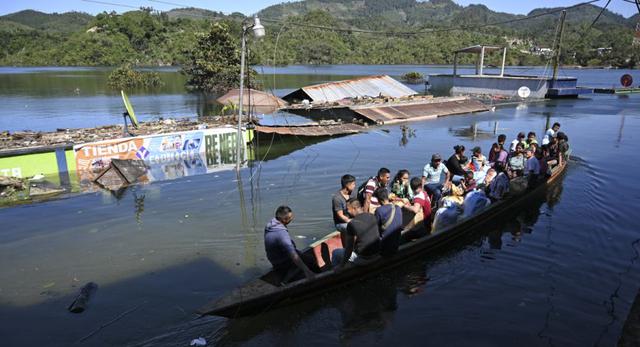 Residentes viajan en bote por una calle inundada de la comunidad indígena Comunidad Campur, Guatemala. (Johan ORDONEZ / AFP)