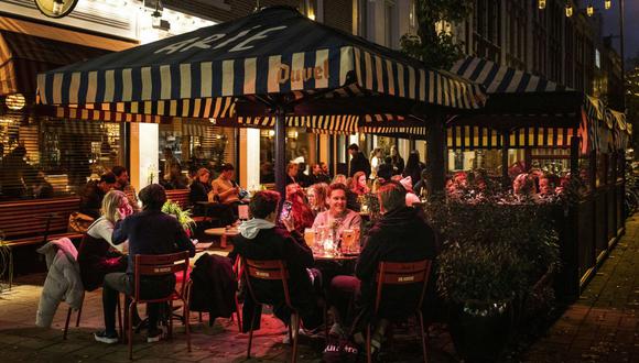 Los consumidores están en la terraza de un café-restaurante de Ámsterdam, el 13 de noviembre de 2021, en pleno rebrote del coronavirus. (Ramon van Flymen / ANP / AFP).