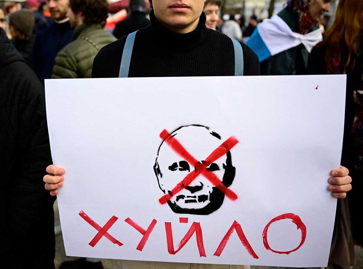 Un manifestante sostiene un cartel que representa al presidente ruso Vladimir Putin tachado durante una protesta cerca de la embajada rusa en Berlín el 17 de marzo de 2024. (Foto de Tobias SCHWARZ / AFP)