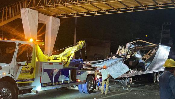 Trabajadores retiran el contenedor del tráiler de un camión que se estrelló con migrantes a bordo durante un accidente de tránsito en Tuxtla Gutiérrez, estado de Chiapas, México, el 9 de diciembre de 2021.  (Foto de GABRIELA COUTINO / AFP)