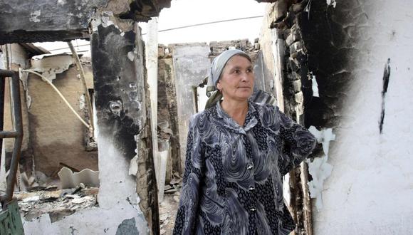 Kirguist&aacute;n. Una mujer al lado de su casa destruida. (Reuters)