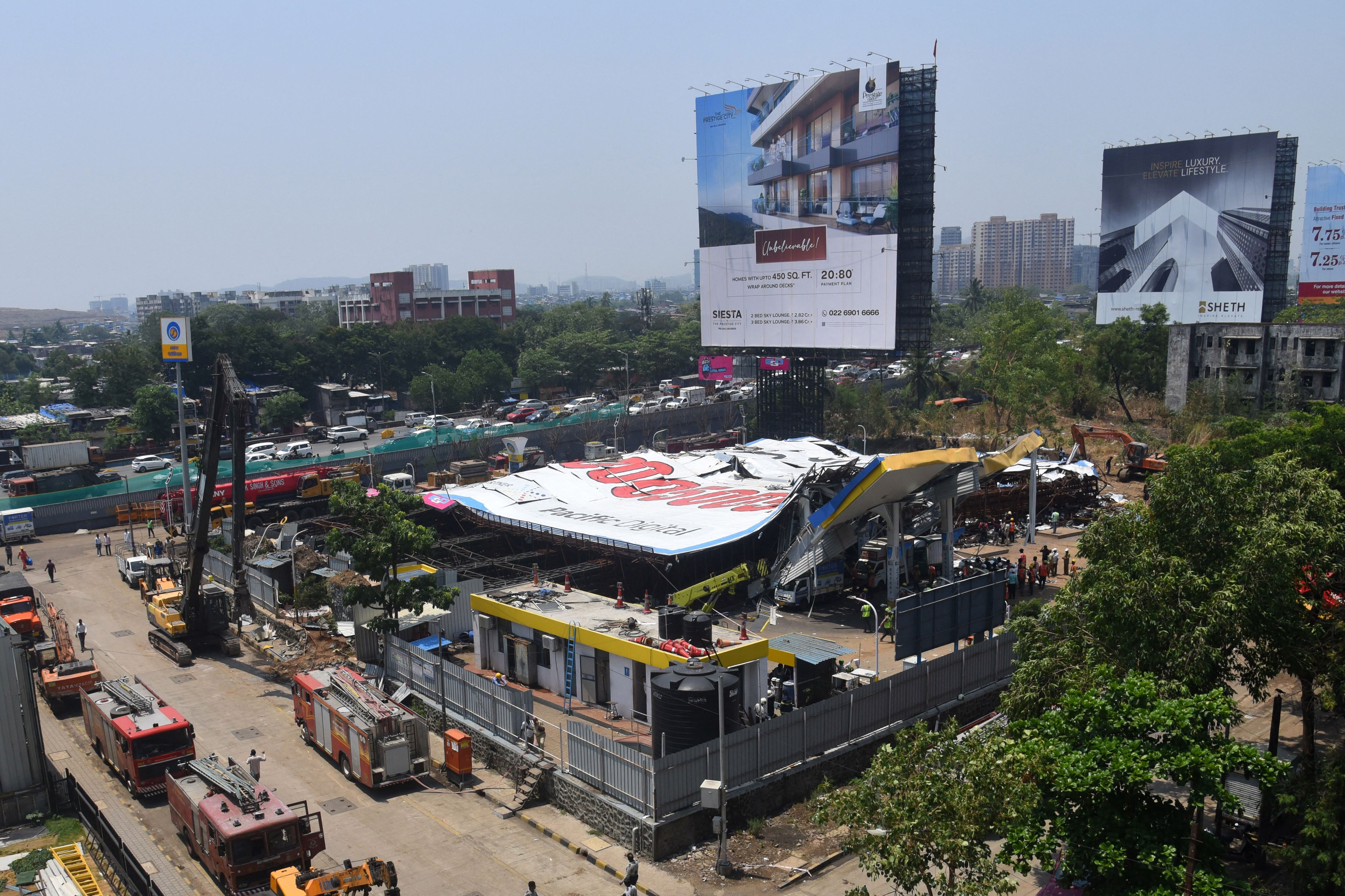 Emergency vehicles are seen parked at the scene a day after a billboard collapsed at a gas station following a storm, in Mumbai on May 14, 2024. (Photo by Imtiyaz SHAIKH/AFP)