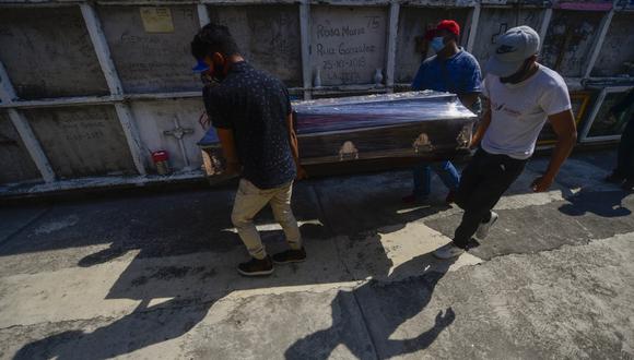 Las personas participan en el funeral de su familiar víctima de COVID-19, en el cementerio municipal de Nezahualcóyotl, estado de México, México, el pasado 20 de enero de 2021. (PEDRO PARDO / AFP)