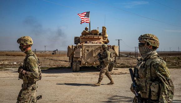 Soldados de Estados Unidos caminan mientras patrullan los campos petroleros de Suwaydiyah, en la provincia de Hasakah, en el noreste de Siria, el 13 de febrero de 2021. (Delil SOULEIMAN / AFP).