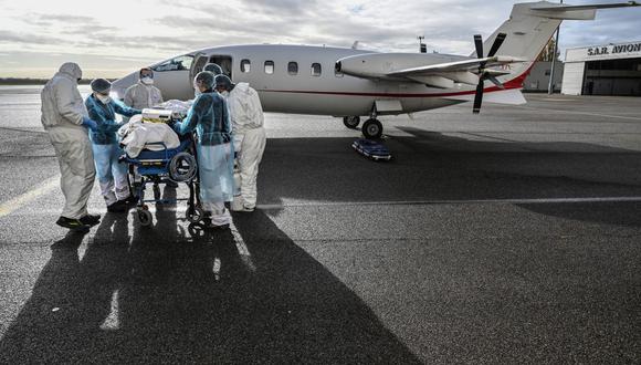 Personal médico transporta a un paciente a una avioneta para ser llevado a otro hospital cerca de Lyon, sureste de Francia, el 16 de noviembre de 2020. (Foto de Philippe DESMAZES / POOL / AFP).
