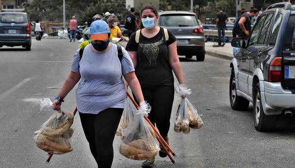 Voluntarios distribuyen pan en Beirut. La destrucción del puerto de Beirut limitó aún más el acceso a la comida en un país que importa el 85% de sus alimentos. (Foto: EFE / EPA / NABIL MOUNZER).