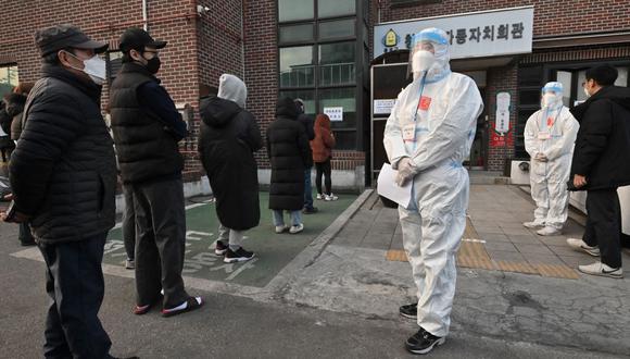 Los funcionarios electorales de Corea del Sur con equipo de protección contra el coronavirus guían a los votantes durante las elecciones presidenciales del 9 de marzo de 2022. (Jung Yeon-je / AFP).
