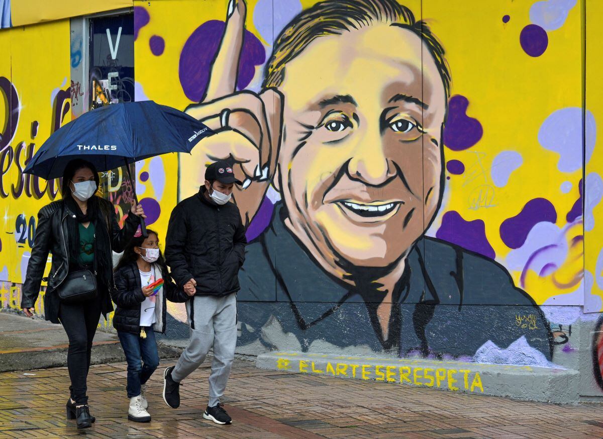 Locals walk past a mural depicting Colombian independent presidential candidate Rodolfo Hernández, in Bogotá, on May 7, 2022. (Juan BARRETO/AFP)