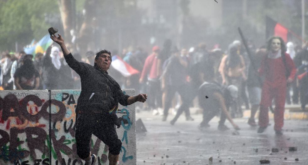 Un manifestante arroja una piedra contra la policía durante una protesta en Santiago. (AFP / Rodrigo ARANGUA).