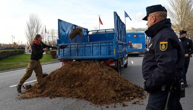 Activistas de Extinction Rebellion vuelcan un camión de estiércol en Madrid. (Foto: AFP).