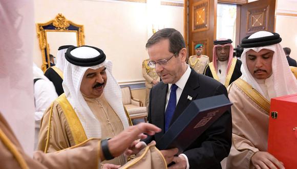 El rey de Bahréin, Hamad bin Isa al-Khalifa (derecha), recibe un regalo del presidente israelí, Isaac Herzog, en la capital, Manama, el 4 de diciembre de 2022. (Foto de Amos Ben-Gershom / GPO / AFP)