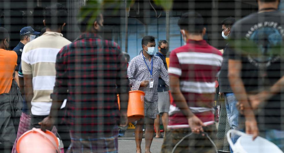 Un grupo de residentes hace cola para obtener comida en el dormitorio de trabajadores extranjeros de Tuas South, que se ha puesto bajo restricción gubernamental como medida preventiva contra la propagación del coronavirus COVID-19 en Singapur. (Roslan RAHMAN / AFP)