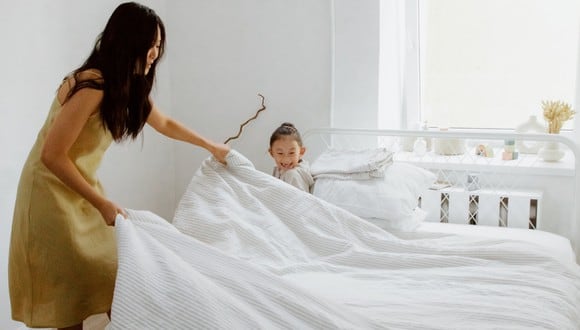 Mamá y su pequeña hija ordena la cama de la habitación. (Imagen: Ron Lach / Pexels)