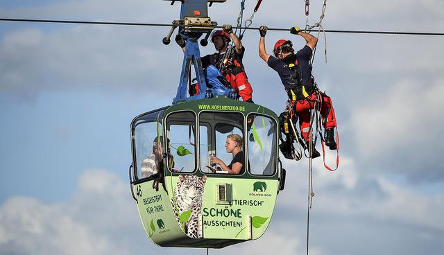 -FOTODELDIA- epa06117982 German fire crews evacuate as many as 100 passengers from suspended cable cars that run over the river Rhine after a gondola ran into a support pillar in Cologne, Germany, 30 July 2017. Public transportation authorities for the city in North-Rhine-Westphalia state say 32 of the cars were operating when the mishap occurred Sunday. When the one car collided with the pillar, the others were brought to a stop. The fire department officials say that as many as 100 passengers were left stranded. EPA/SASCHA STEINBACH