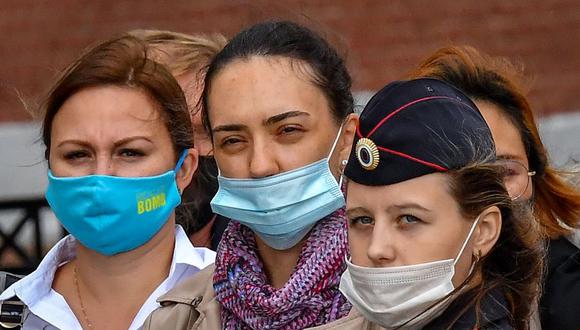 Tres mujeres que usan mascarillas faciales para protegerse del coronavirus caminan por el centro de Moscú el 17 de septiembre de 2020. (Foto de Yuri KADOBNOV / AFP).