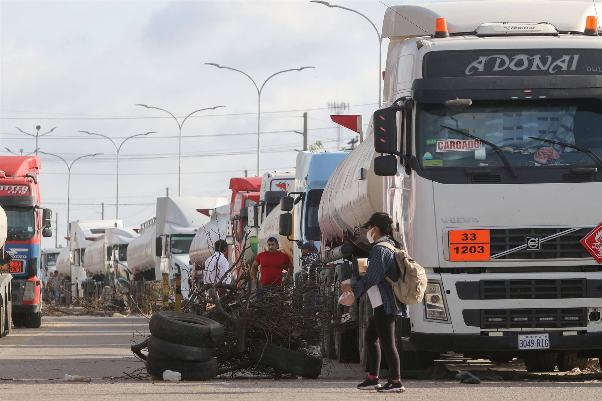 A woman walks past a blockade at the Guillermo Elder Bell refinery in Santa Cruz, Bolivia.  (EFE/Juan Carlos Torrejon).